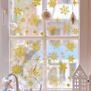 Close-up of golden glitter snowflake and star window stickers for Christmas decoration