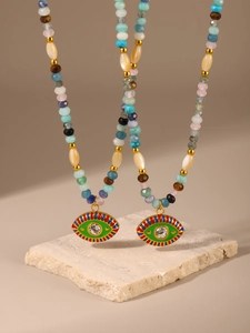 Macro shot of colorful beaded necklaces with evil eye pendants on stone background