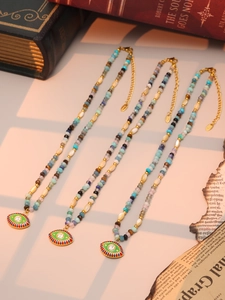 Close-up of bohemian devil's eye necklaces with colorful beads and gold metal details