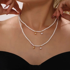 Double-layered pearl choker necklace with gold heart pendant and teardrop zircon accents