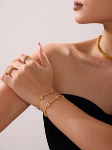 Model trägt vergoldetes 18K Schmuckset mit Herz-Zirkonia-Armbändern und Ringen