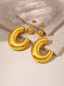 Detailed shot of C-shaped chunky gold earrings with ball back and butterfly backing