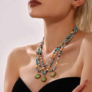 Three-layer beaded Evil Eye necklace with blue and gold accents on model