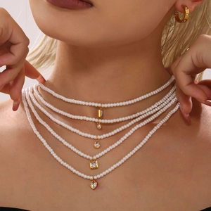 Elegante collana di perle a strati con ciondoli geometrici in zircone dorato