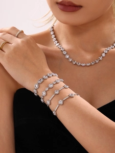 Detail shot of a sparkling silver-toned jewelry set with zircon bracelets and a necklace