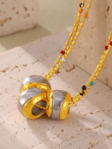 Macro view of gold and silver LOVE engraved pendant with colorful beads on a ball chain