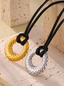 Detalle de la textura acolchada en colgantes redondos de oro y plata con cordones