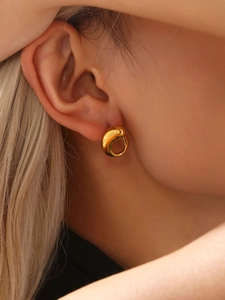 Close-up of elegant gold water drop earrings with polished 18K finish on earlobe