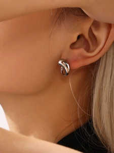Close-up of a silver water drop earring with a polished organic curved design for women