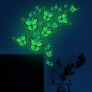 Luminous butterfly and star wall stickers glowing bright green in a dark bedroom