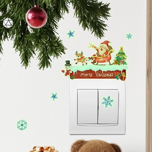 Leuchtende Weihnachtsaufkleber mit Weihnachtsmann, Rentier und Schneemann auf weißer Wand