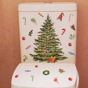 Vue détaillée d'autocollants sapin de Noël et pain d'épices sur abattant de WC blanc