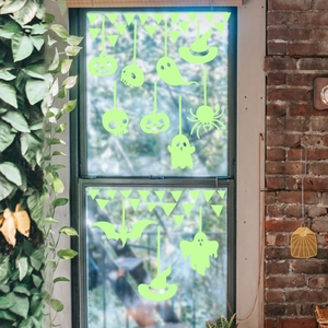 Luminous Halloween window decals featuring ghosts and pumpkins on a glass window pane