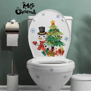 Détail de stickers bonhomme de neige et sapin de Noël posés sur un abattant WC
