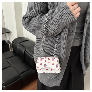 Modische Mini-Kettenumhängetasche mit Lippenprint getragen zu einem lässigen Winteroutfit