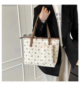 Close-up of a large printed tote bag set with matching zipper pouch and brown straps