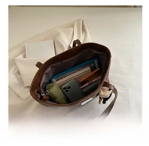 Internal view of brown leather tote bag showing large capacity for tablet and daily items