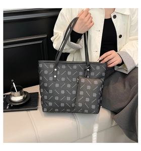 Detail of black tote bag set featuring clover print and matching zipper pouch accessory