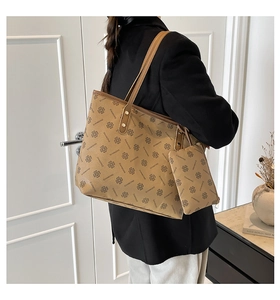 Detail of vintage brown tote bag with clover monogram pattern and small matching pouch