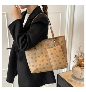 Detail of light brown monogram tote bag set with matching zipper pouch on model