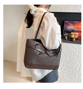Détail d'un grand sac cabas marron foncé avec boucle vintage porté par un mannequin
