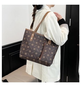 Detail shot of vintage patterned tote bag with detachable pouch and golden hardware