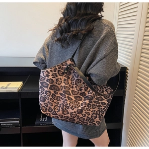 Detailed side view of large leopard print tote bag with black strap on model