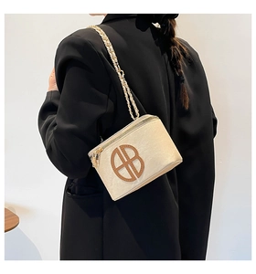 Detail of minimalist cream faux leather crossbody bag with brown circular cutout logo