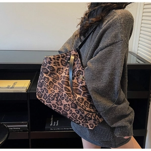 Close-up of leopard print tote bag with black leather straps in a lifestyle setting