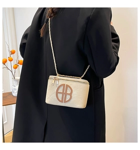 Chic cream leather square bag featuring distinctive circular logo detail and gold chain