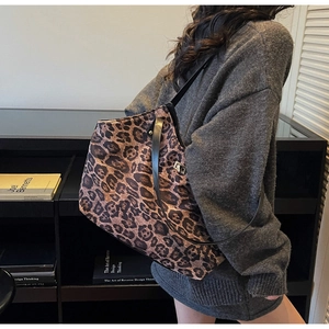 Detailed side view of a large leopard print tote bag worn with a casual sweater