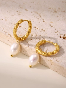 Detail of 18K gold-plated twisted hoops with natural freshwater pearls on a stone base