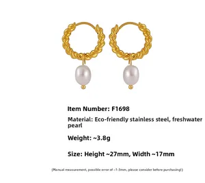 Macro detail of 18K gold plated twist hoop earrings with white freshwater pearl drops