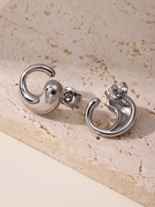 Macro shot of silver teardrop stud earrings on stone tray with butterfly backings
