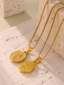 Detail of gold-plated stainless steel religious medallions with Virgin Mary relief on box chain