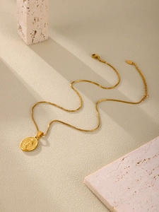 Close-up of golden stainless steel religious medal necklace with box chain and lobster clasp