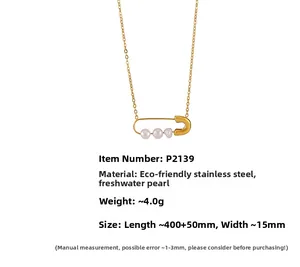 Detailed shot of a gold stainless steel safety pin necklace with three white freshwater pearls