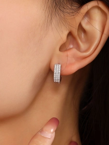 Primo piano di orecchini a cerchio con pavé di zirconi in finitura argento lucido