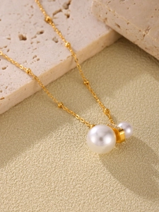 Detail der Goldkette mit doppelten weißen Perlen und funkelndem Zirkon-Rechteckglied