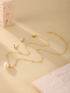Details des luxuriösen Edelstahl-Schmucksets mit weißen Perlen und Zirkonia auf Stein
