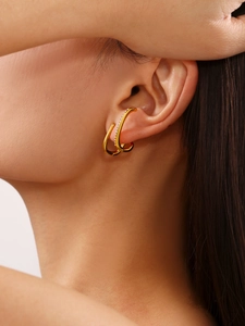 Dettaglio dell'ear cuff dorato con zirconi incastonati indossato sull'orecchio