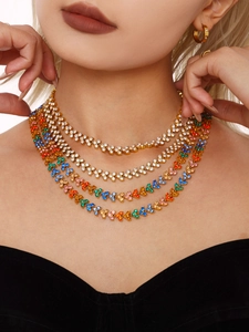 Macro shot of layered 18K gold plated necklace with colorful zircon stones and earrings