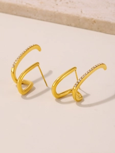 Dettaglio di ear cuff a spirale dorati con pietre di zircone bianco incastonate a mano