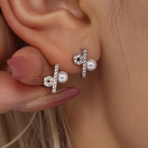 Elegante geometrische Edelstahl-Ohrstecker mit weißer Perle und Zirkonia am Model