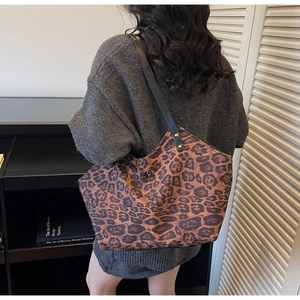 Detail view of large leopard print tote bag with metallic turn-lock and black straps