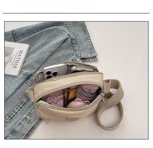 Top view of beige nylon crossbody bag showing spacious interior with multi-compartments