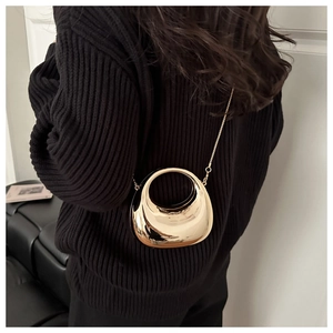 Detail van mini gouden halve maan tas met rond handvat en metallic kettingriem