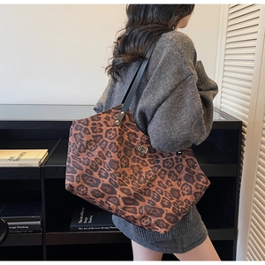 Close-up of large leopard print tote bag with metal lock and black leather shoulder strap