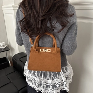 Retro brown suede tote bag with golden square buckle shown worn by a female model