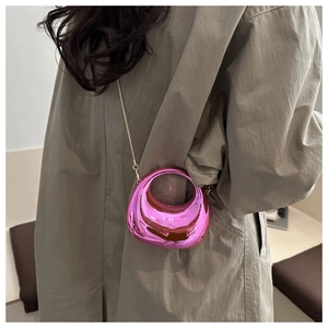Detailopname van de metallic roze crescent tas met gouden ketting op trenchcoat-achtergrond